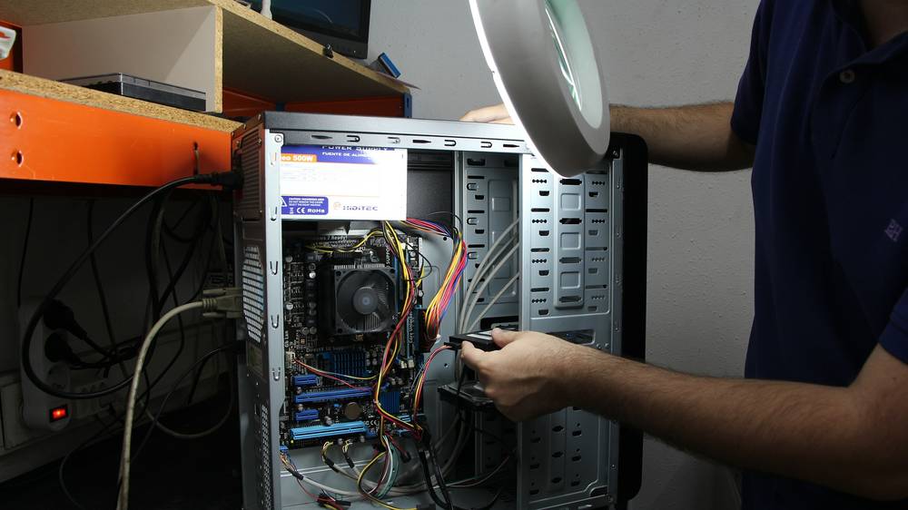 Techniker baut eine Festplatte in einen ge&ouml;ffneten Desktop-PC ein
