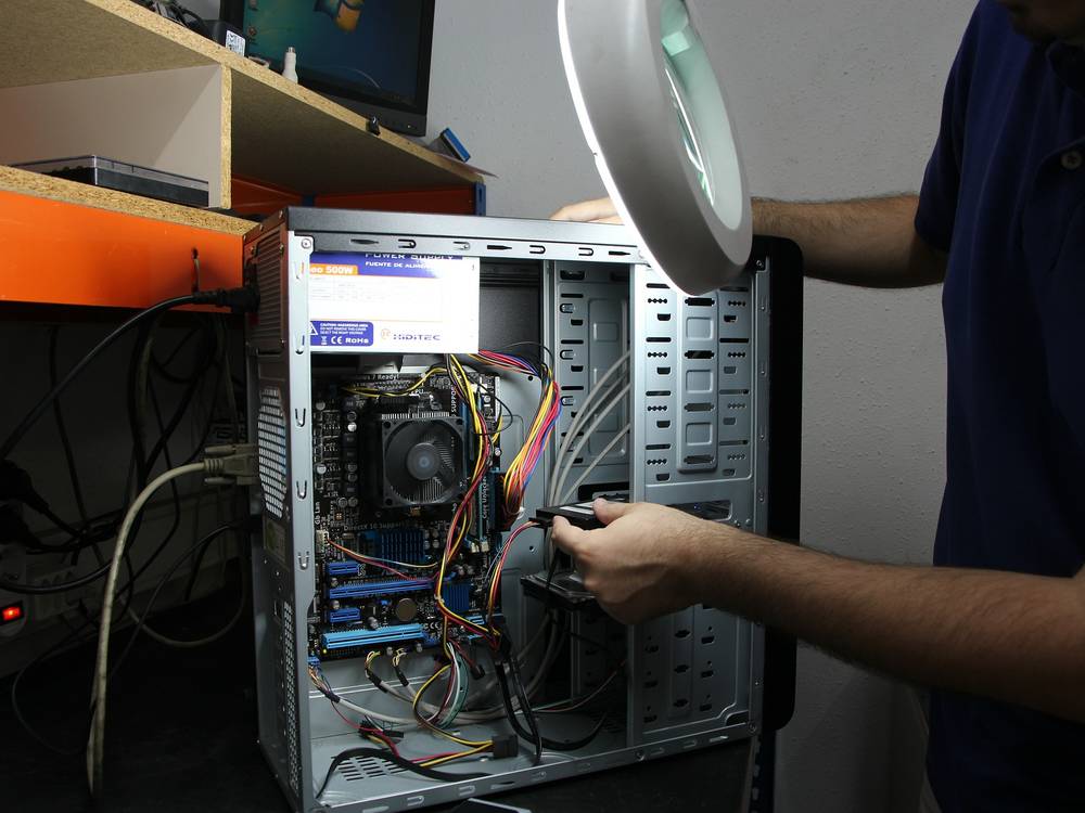 Techniker baut eine Festplatte in einen ge&ouml;ffneten Desktop-PC ein
